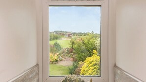 A view from a window with a view of a garden and a distant building. - 1 bedroom accommodation in Harriseahead (Harriseahead)