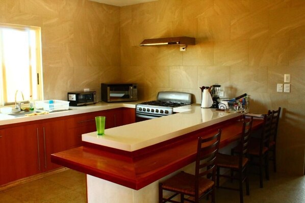 A kitchen with a central island, a stove, a microwave, and a sink.