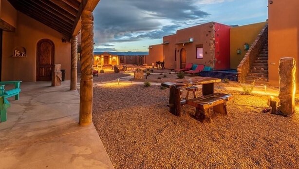 An outdoor courtyard with rustic wooden benches and a stone pathway.
