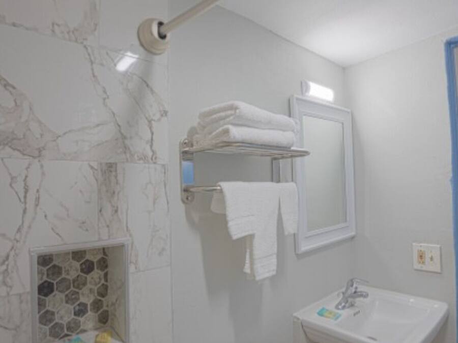 A bathroom with a toilet, sink, and towel rack.