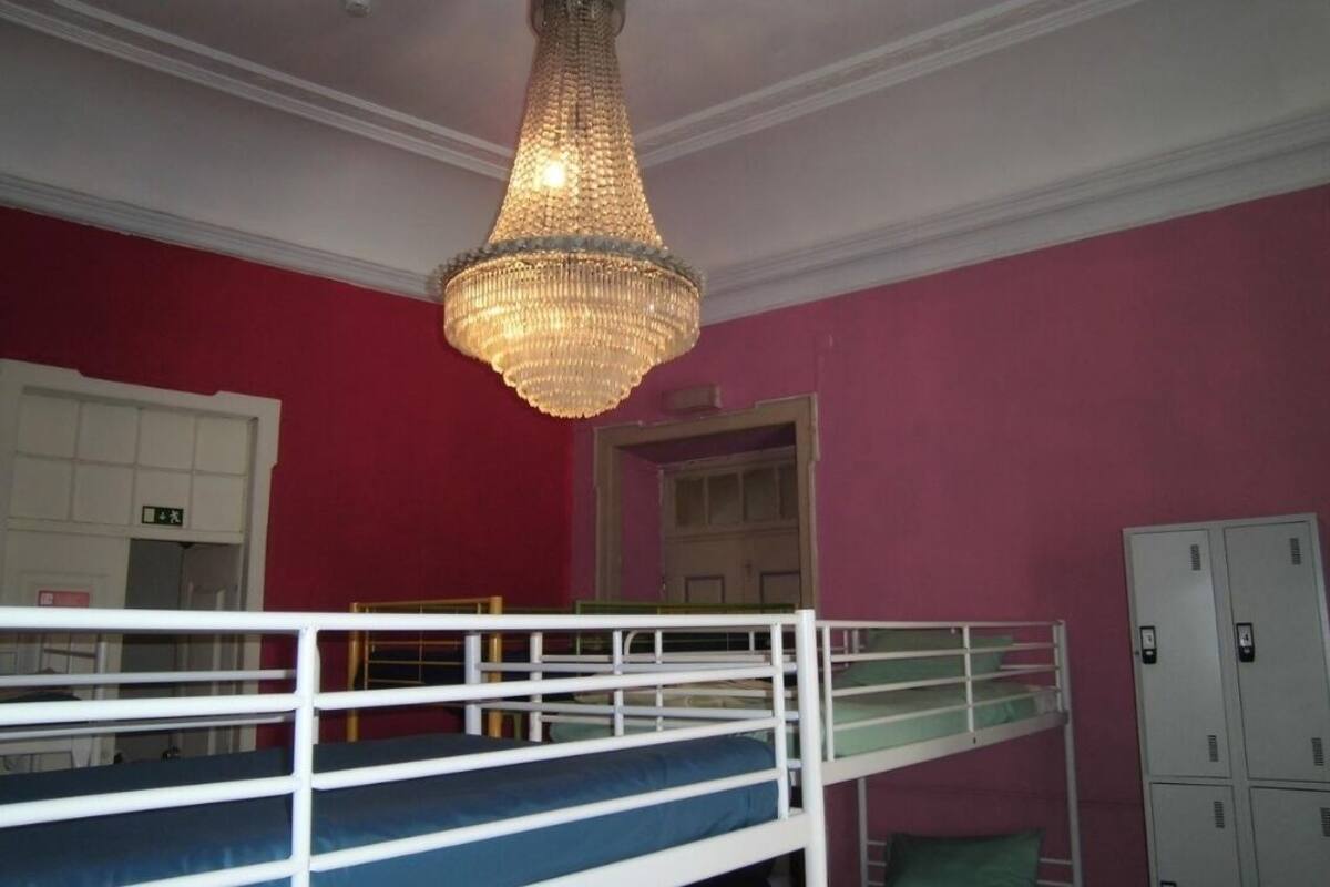 A bunk bed room with a chandelier, a door, and a set of lockers.