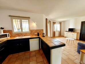 Enjoy a compact kitchen with microwave, sink, and dishwasher, and a cozy dining area with a table and chair.
