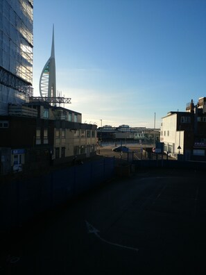A view of a cityscape with a prominent tower and a circular building, surrounded by modern buildings and a clear sky. - College Street Abode - Guest House (Portsmouth)