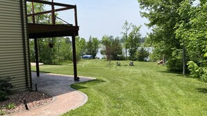 A well-maintained lawn with a paved walkway leading to a covered patio area. - Hidden Charm Suites - Peaceful Suite Lake Retreat (Lapeer)