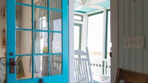 A turquoise door with a glass panel, a white chair with a cushion, and a wooden bench. - Clean Waterfront Classic Cottage with Private Beach (Gloucester)