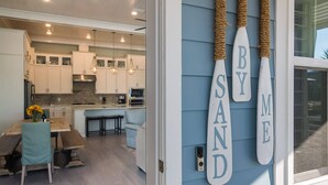 A modern kitchen with white cabinets, a central island, and pendant lighting.