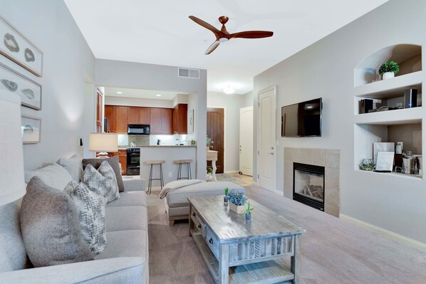 A living room with a sofa, coffee table, and fireplace. - Heritage Retreat 2 | 2BR Legacy Villa (La Quinta)