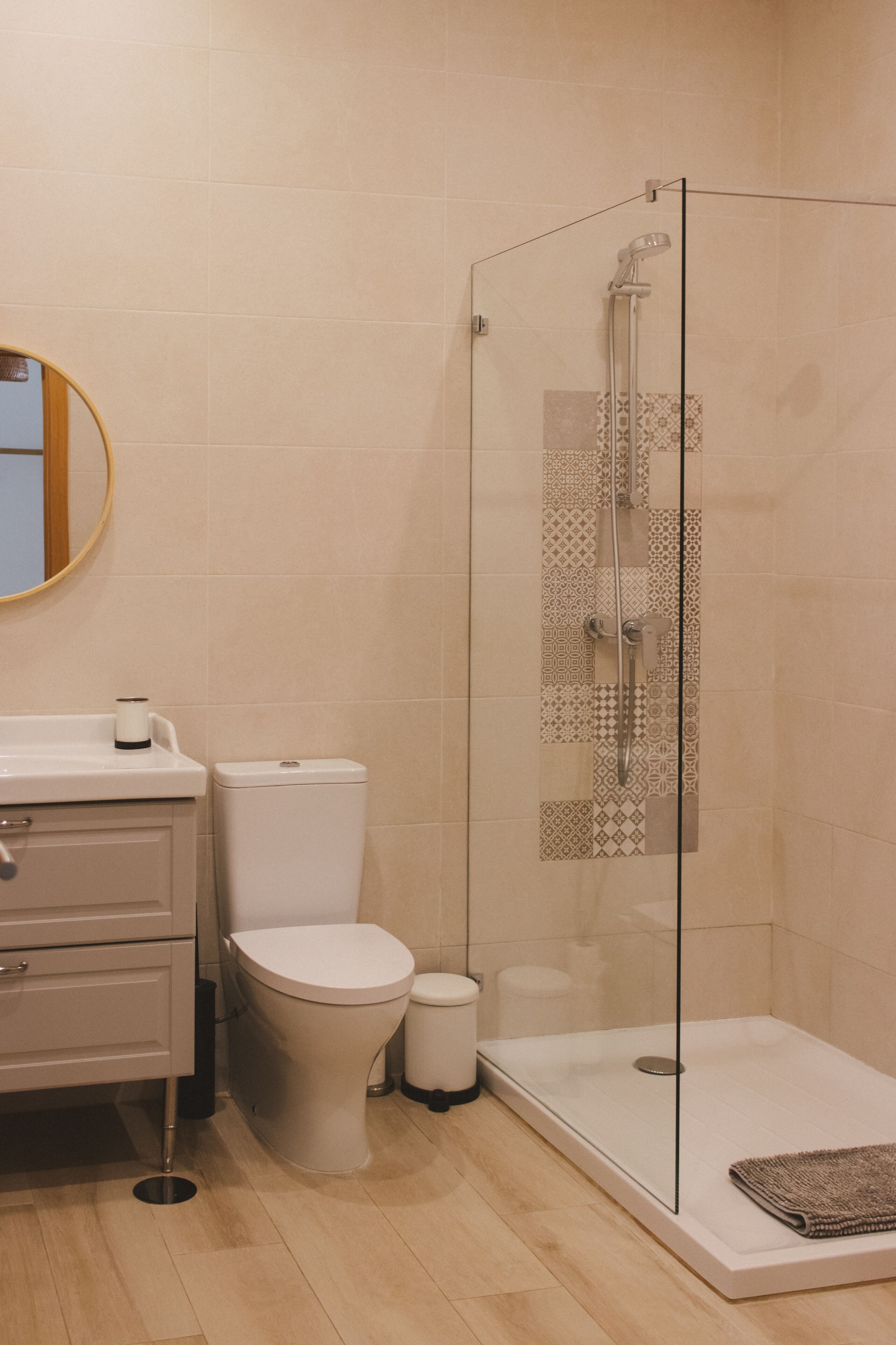 A modern bathroom with a toilet, bidet, and glass-enclosed shower.