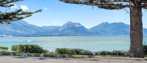 A coastal road with a view of a lake and mountains.