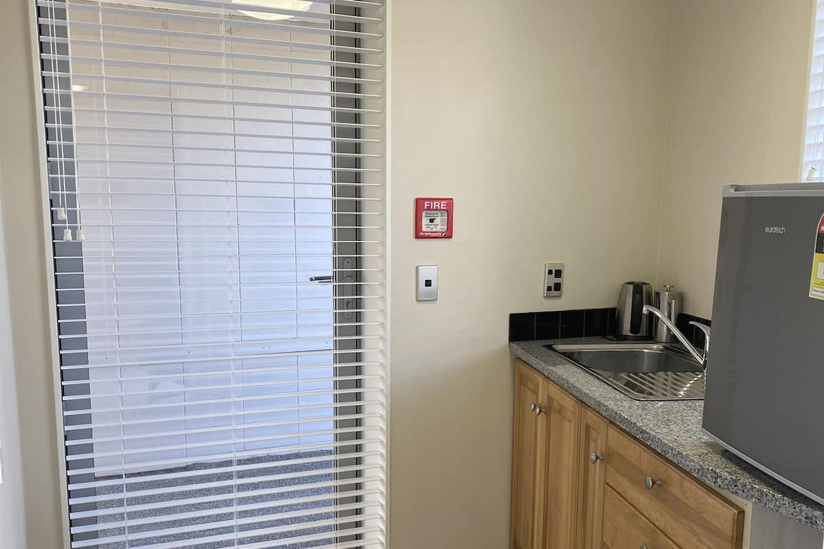 A kitchen with a built-in stove, a sink, and wooden cabinets.
