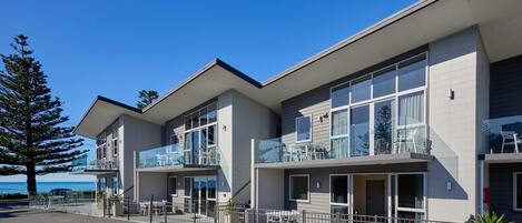 A modern building with multiple balconies and large windows, likely a hotel or apartment complex.