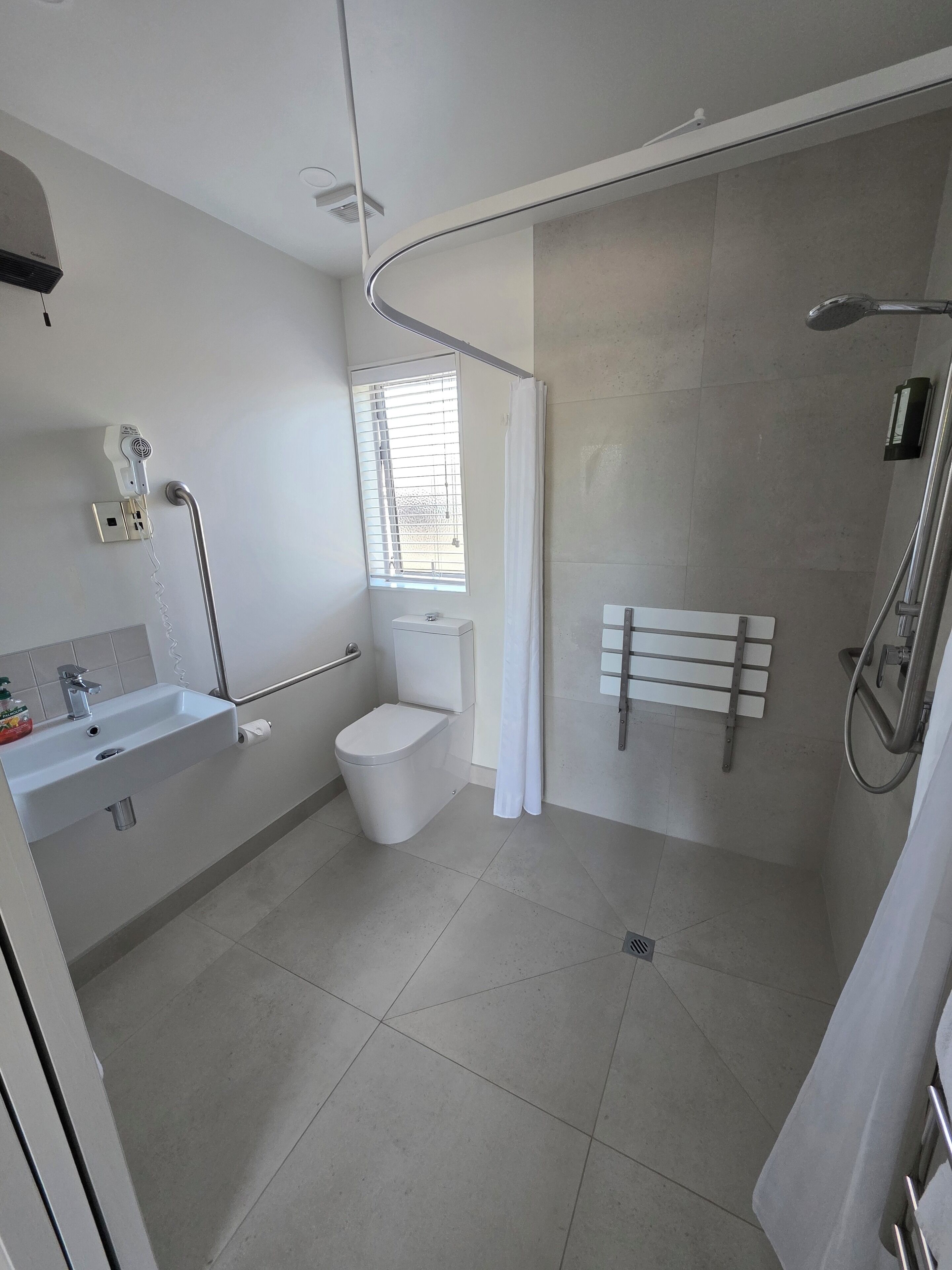 A modern bathroom with a toilet, sink, and shower.