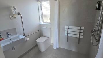 A modern bathroom with a toilet, sink, and shower.