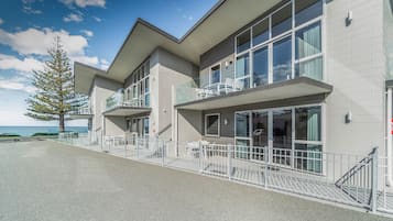 Un edificio moderno con balcones, ventanas grandes y vista al mar.