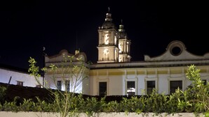 Un edificio con una torre de campanas destacada y fachada blanca.