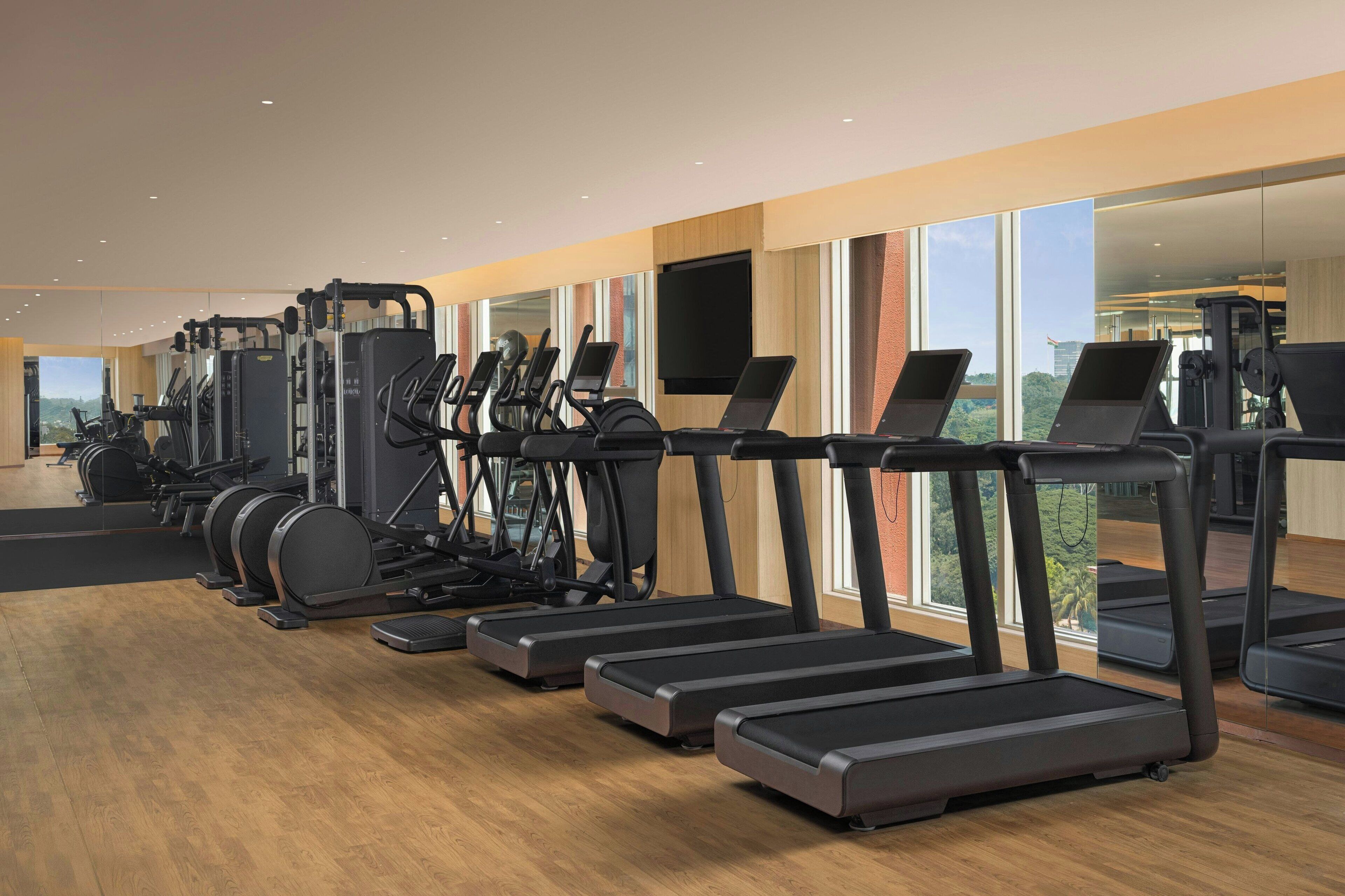 A gym with treadmills, elliptical machines, and weight equipment.