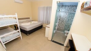 A bedroom with bunk beds, a bathroom with a glass shower, and a small desk area. - Pousada Morada Dos Anjos (Penha)