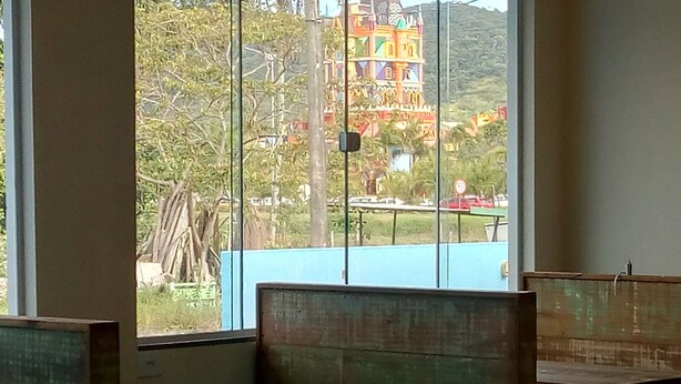 A room with wooden benches and a large window. - Pousada Morada Dos Anjos (Penha)