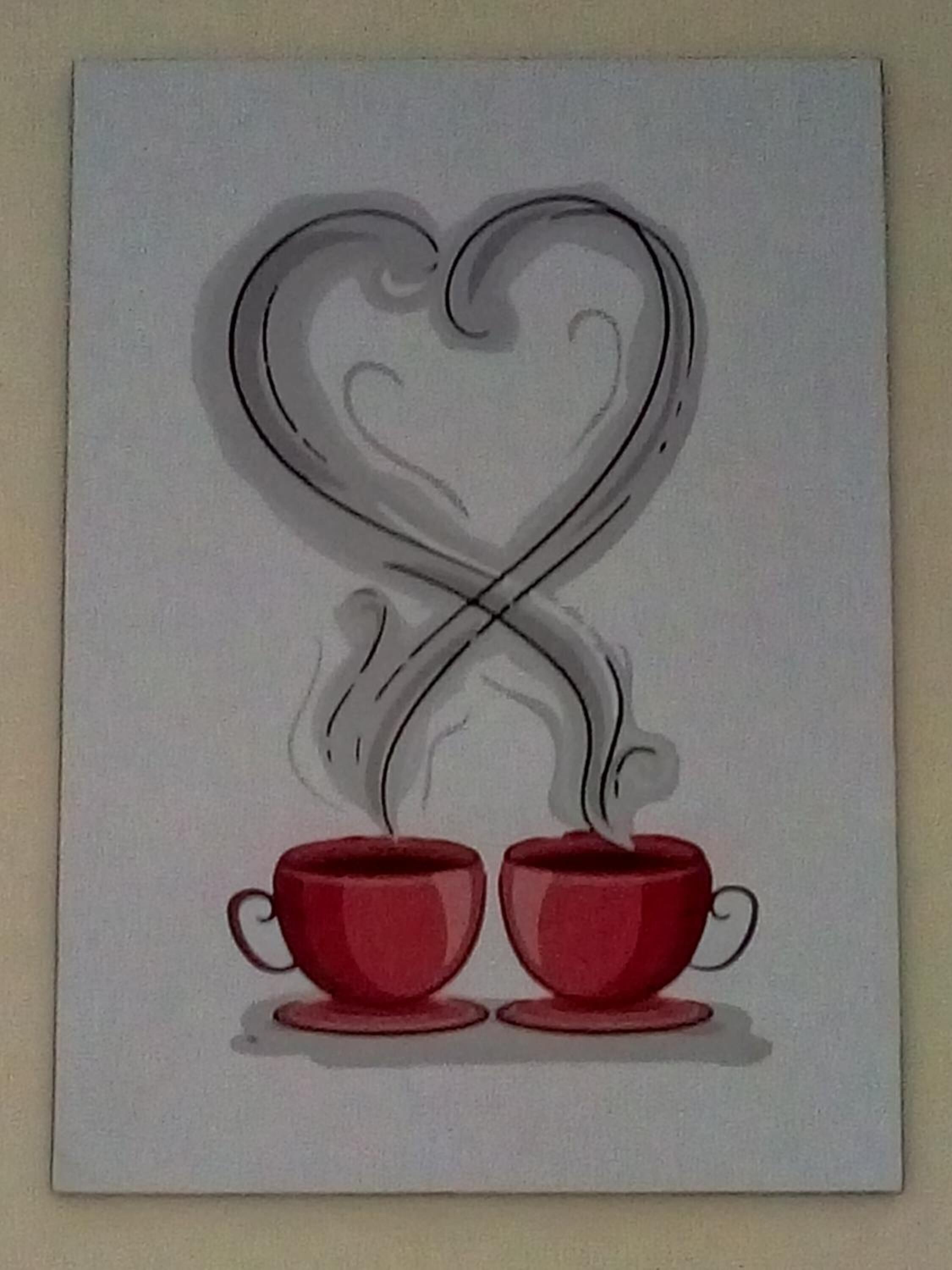 A framed artwork of two red cups with steam rising from them, forming a heart shape above.