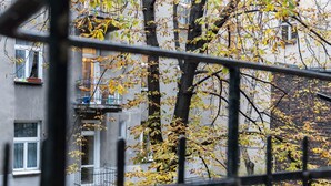A building with multiple windows and balconies, surrounded by trees with autumn leaves. - R&R Apart Cracow (Kraków)