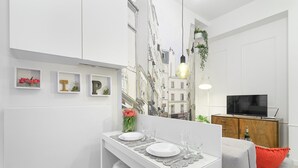 A modern apartment with a dining area, a living room, and a TV. - R&R Apart Cracow (Kraków)