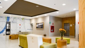 Un vestíbulo moderno con zonas de estar, un mapa en la pared y una recepción.