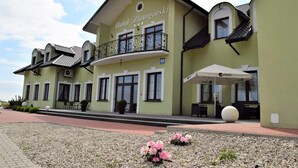 A hotel with a green facade, a balcony with ornate railings, and a sign reading "Hotel Zlotogórski". - Hotel Zlotogorski (gmina Koscielec)