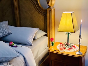 A neatly made bed with blue pillows and a single rose on the bedspread. - Rooibos Retreat (Richards Bay)