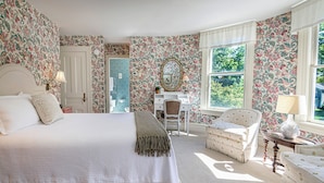 A bedroom with a large bed, a desk, a chair, and a window. - The West Lane Inn - Queen Room (Ridgefield)