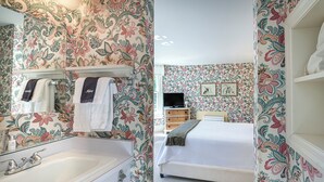 A bathroom with a large mirror, a sink, and two towels hanging on a rack. - The West Lane Inn - Queen Room (Ridgefield)