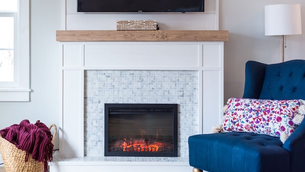 A modern living room with a fireplace, a mounted TV, and a blue sofa. - Blue Cottage in the heart of Tulsa (Tulsa)