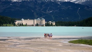 Um hotel grande com vários edifícios e um lago ao primeiro plano.