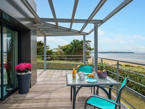 Enjoy the ocean view from this balcony with a table and chairs, perfect for a morning coffee or snack.