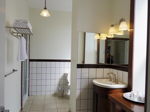Une salle de bain équipée de toilettes, d’un lavabo et d’un porte-serviettes.
