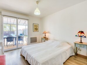 A bedroom with a bed, a desk, a chair, a table, and a lamp. - Wonderful private villa for 8 people with private pool, WIFI, TV, terrace and pets allowed (Montalivet-les-bains)