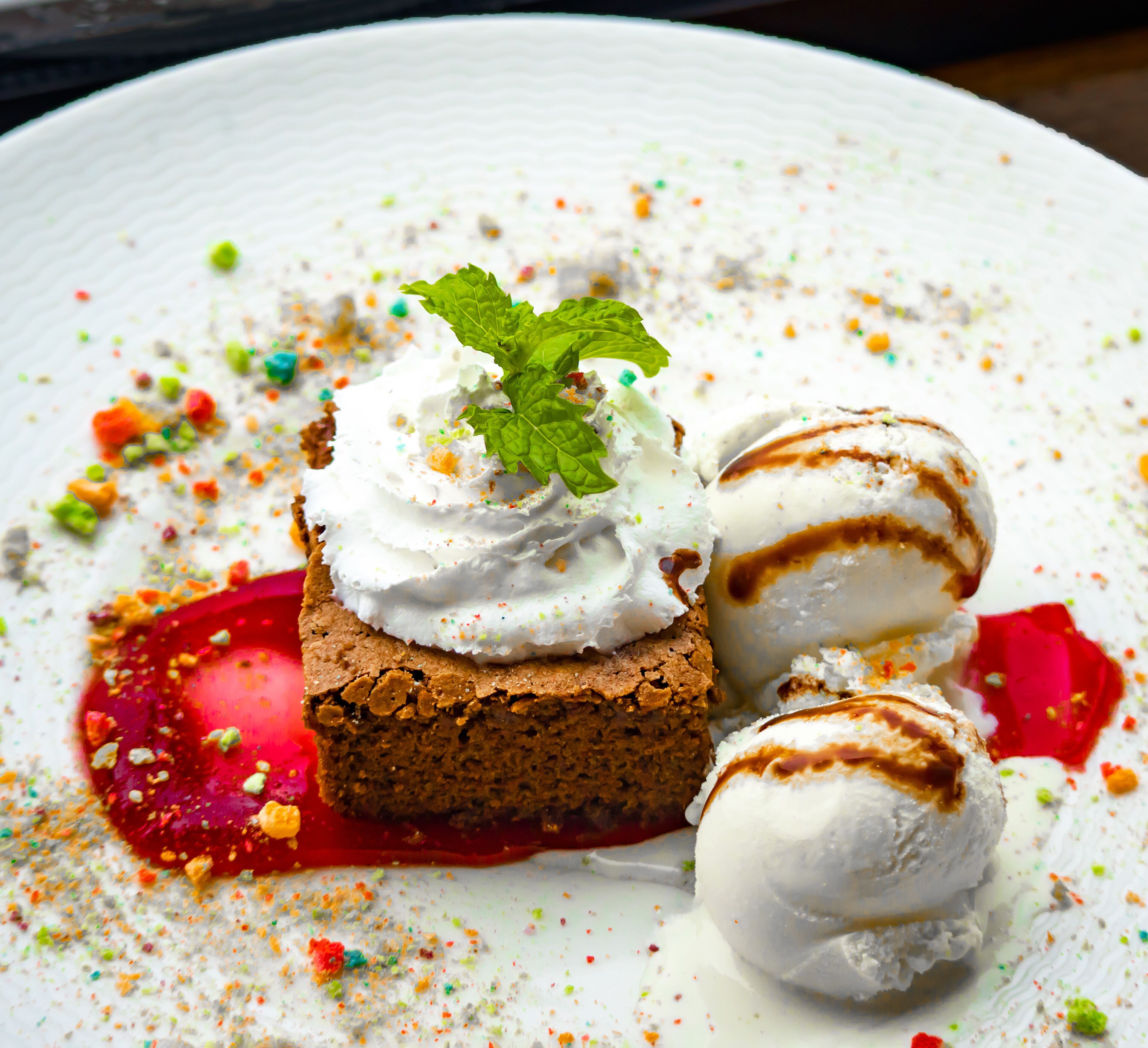 Un postre con helado y una porción de pastel en un plato.