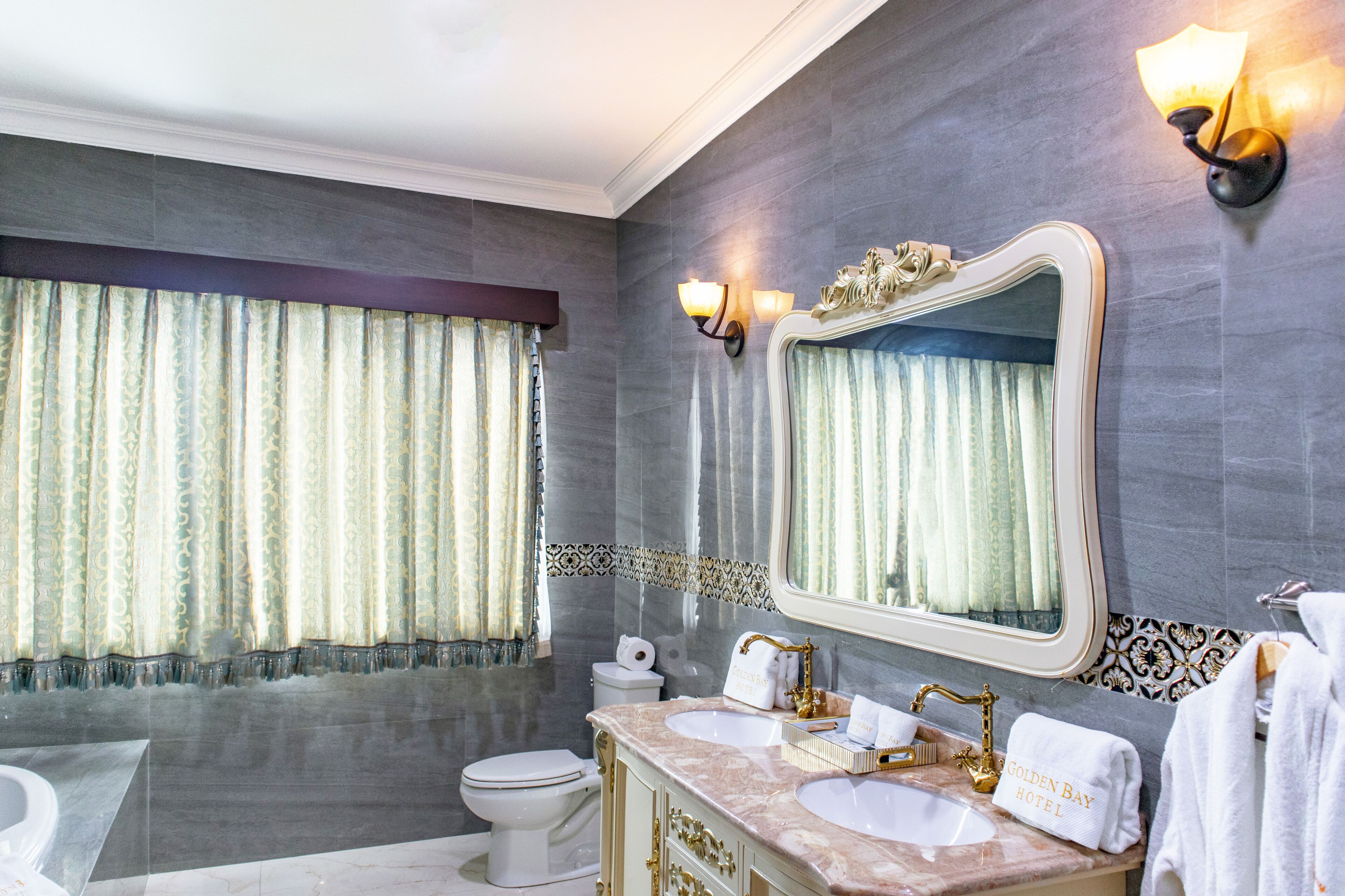 Un baño con dos lavamanos, un espejo grande y una bañera.