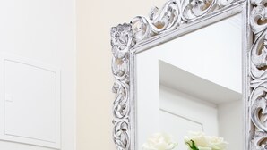 A white dresser with three drawers and a mirror with an ornate frame. - Charming river apartment, Castle view, Breakfast incl. (Praha 5)