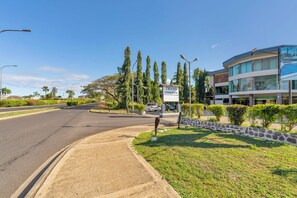 Stylish building with a curved facade and large windows, situated on a well-maintained street.