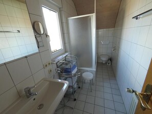 Ein kleines Badezimmer mit Badewanne, Toilette und Duschbereich.