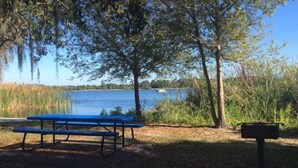 A picnic table and a mailbox by a lake.