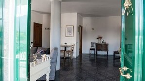 Une pièce comprenant un coin repas, un canapé et une porte verte.