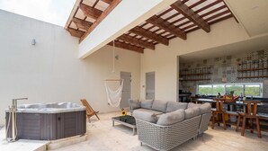 Zona d'estar àmplia amb un banyera d'hidromassatge, un sofà i una taula de menjador.