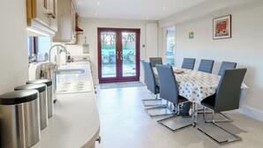 A modern kitchen with a dining area, featuring a kitchen island, stainless steel appliances, and a dining table with chairs. - 4 bedroom accommodation in Inglewhite, near Longridge (Inglewhite, near Longridge)