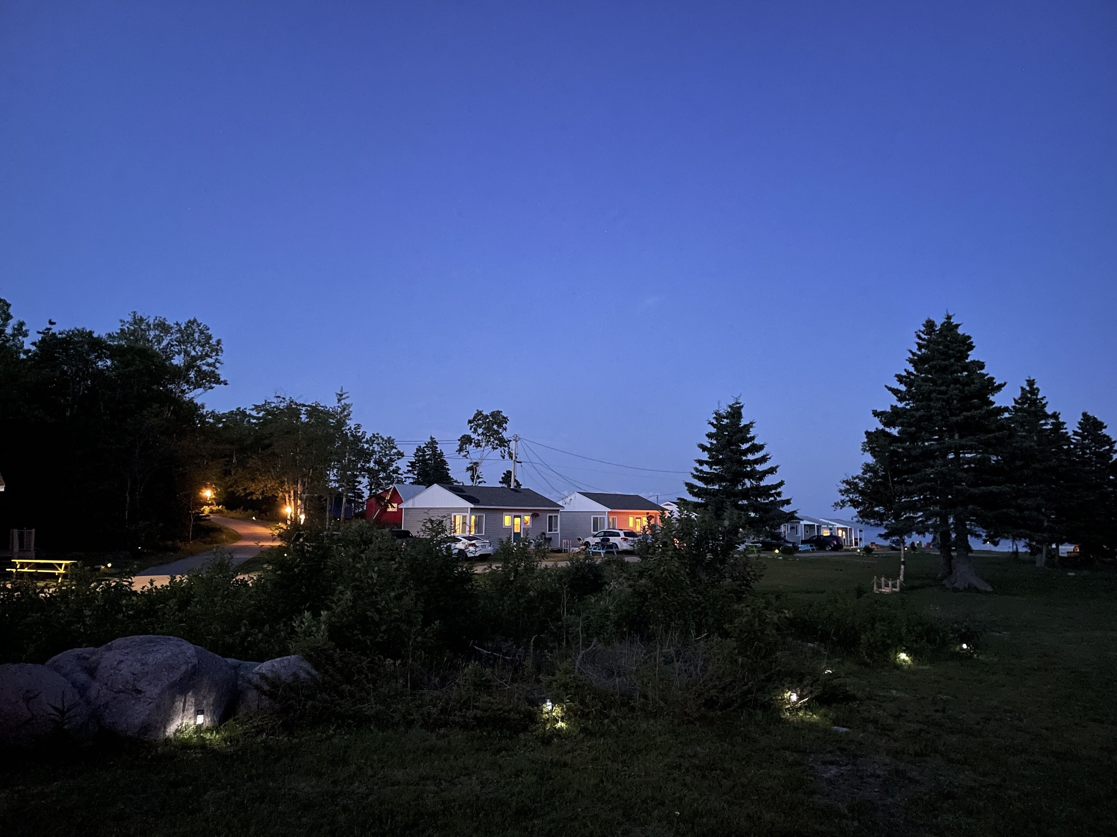 A residential area with houses, trees, and a clear sky.