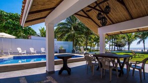 A covered outdoor area with a pool, lounge chairs, and a table. - Beachfront House in Playa Tivives with private pool (Tivives)