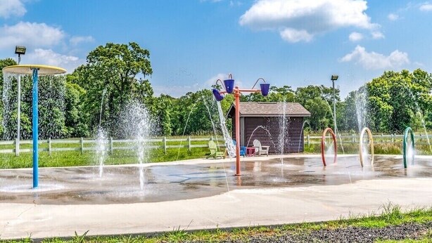 Ein Wasserpark mit verschiedenen Wasserspielen, darunter eine Fontäne und Wasserstrahl-Attraktionen.