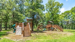 Ein Spielplatz mit Holzkonstruktionen, Rutschen und Treppen.