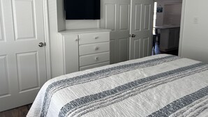 A bedroom with a bed, a dresser, a television, and a closet. - Avalon Stone Harbor - Heart of 7 Mile Island, Beach Block!! (Avalon)