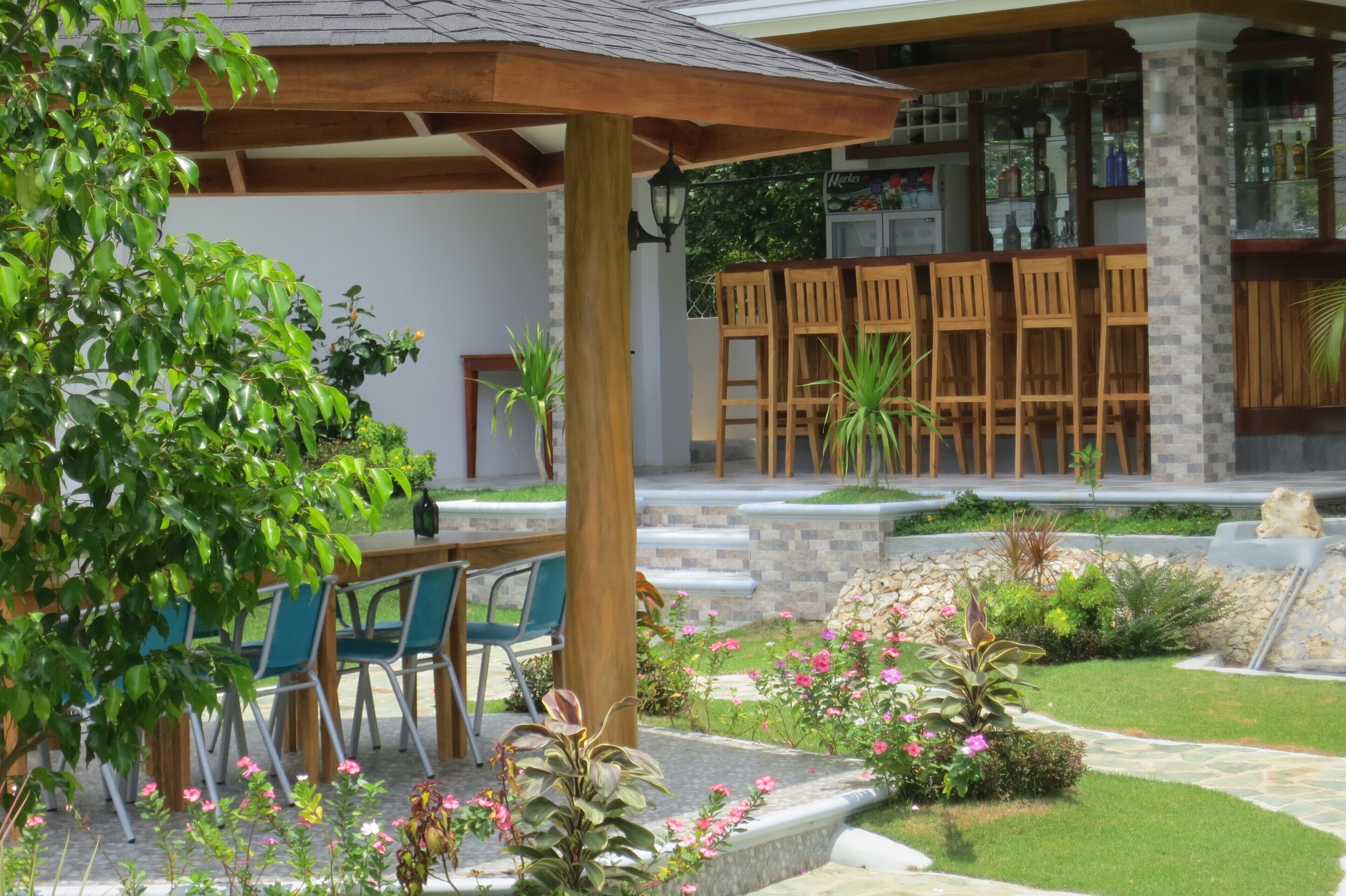 A patio area with outdoor seating, a bar, and a stone pathway.